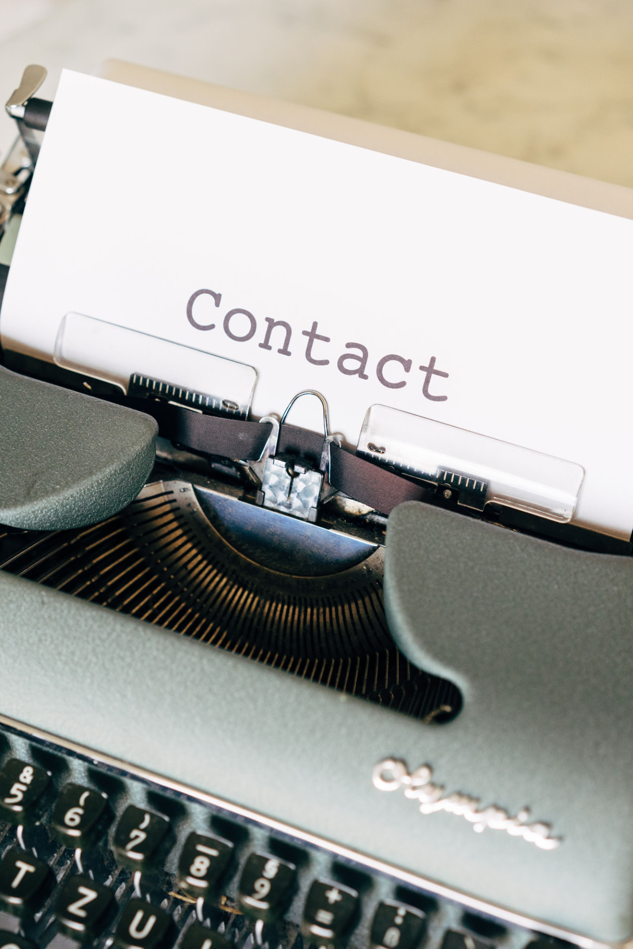 Vintage typewriter with a sheet of paper reading Contact